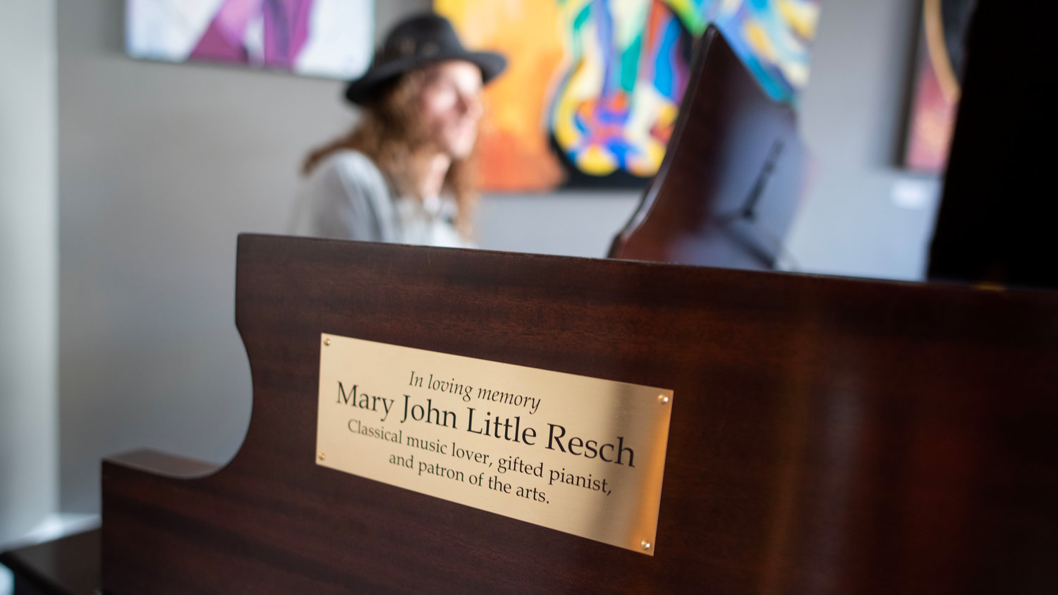A plaque in memory of former Chatham News + Record owner Mary John Little Resch, who died in 2022, adorns a piano donated to the N.C. Arts Incubator in her memory. Dozens of people attended a celebration at the nonprofit art galley Saturday evening to celebrate Resch’s life and the piano she used to own.